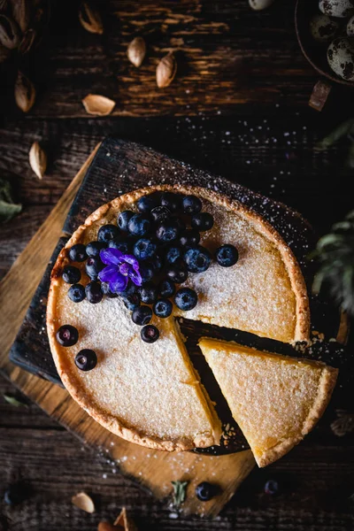 Ahşap masada yaban mersini ile süslenmiş ev yapımı Limon pasta