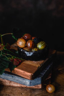 Ahşap arka plan üzerinde siyah taş plaka taze bektaşi üzümü yakın görünümü