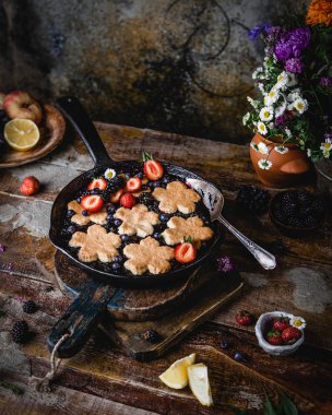 Eski ahşap masada tavada olgun taze çilek ile ev yapımı bisküvi 