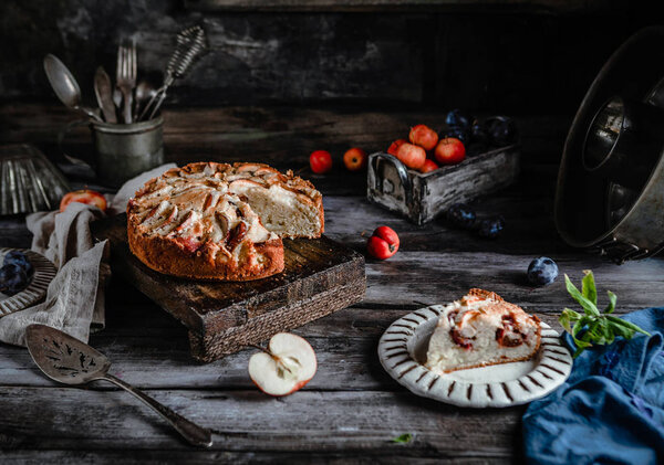 delicious homemade pie with apples and utensil on old dark table 