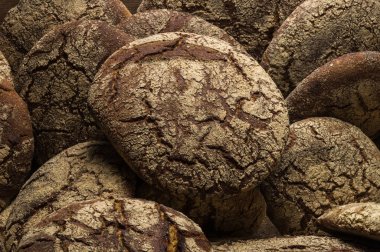 Fırın ekmek üreticileri - altın rustik huysuz somun ekmek ve siyah kara tahta zemin üzerine buns. Natürmort (üstten görünüm yukarıda, düz yatıyordu yakalanan).