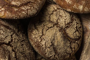 Fırın ekmek üreticileri - altın rustik huysuz somun ekmek ve siyah kara tahta zemin üzerine buns. Natürmort (üstten görünüm yukarıda, düz yatıyordu yakalanan).