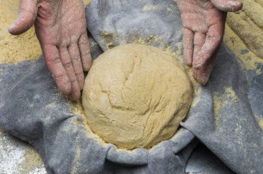 Erkek eller hamur yoğurur un serpilmiş, yakın plan.