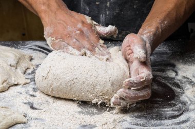 Erkek eller hamur yoğurur un serpilmiş, yakın plan.
