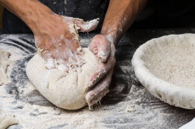 Erkek eller hamur yoğurur un serpilmiş, yakın plan.