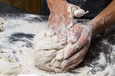 Erkek eller hamur yoğurur un serpilmiş, yakın plan.