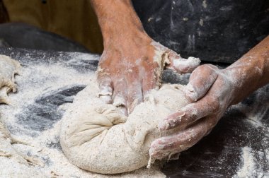 Erkek eller hamur yoğurur un serpilmiş, yakın plan.