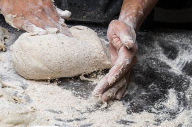 Erkek eller hamur yoğurur un serpilmiş, yakın plan.