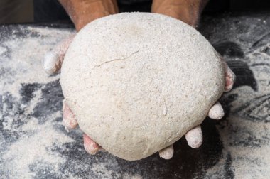 Erkek eller hamur yoğurur un serpilmiş, yakın plan.