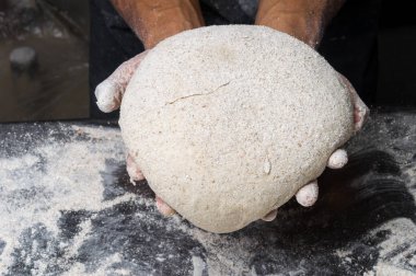 Erkek eller hamur yoğurur un serpilmiş, yakın plan.