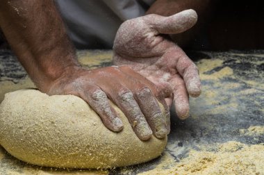 Erkek eller hamur yoğurur un serpilmiş, yakın plan.