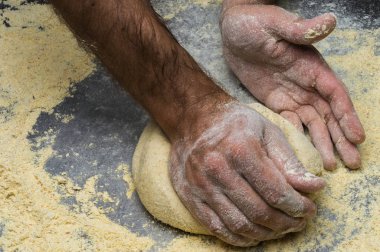 Erkek eller hamur yoğurur un serpilmiş, yakın plan.