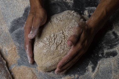 Fırıncı ekmek pişiriyor. Adam hamura un döker. Ekmek yapan adam