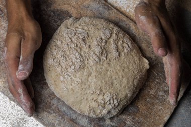 Fırıncı ekmek pişiriyor. Adam hamura un döker. Ekmek yapan adam