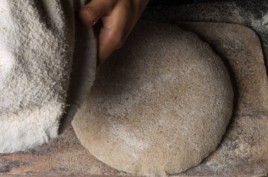 Fırıncı ekmek pişiriyor. Adam hamura un döker. Ekmek yapan adam