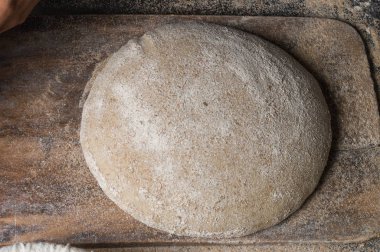 Fırıncı ekmek pişiriyor. Adam hamura un döker. Ekmek yapan adam