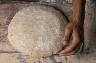 Fırıncı ekmek pişiriyor. Adam hamura un döker. Ekmek yapan adam