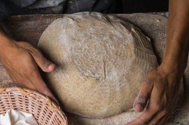 Fırıncı ekmek pişiriyor. Adam hamura un döker. Ekmek yapan adam