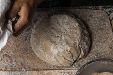 Fırıncı ekmek pişiriyor. Adam hamura un döker. Ekmek yapan adam