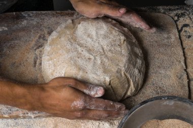 Fırıncı ekmek pişiriyor. Adam hamura un döker. Ekmek yapan adam