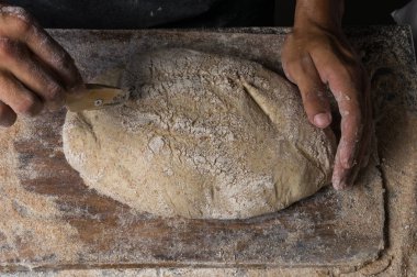 Fırıncı ekmek pişiriyor. Adam hamura un döker. Ekmek yapan adam