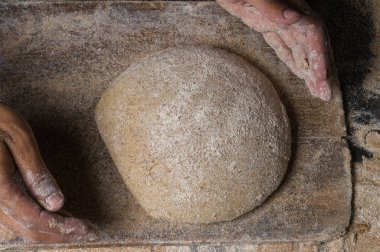 Fırıncı ekmek pişiriyor. Adam hamura un döker. Ekmek yapan adam