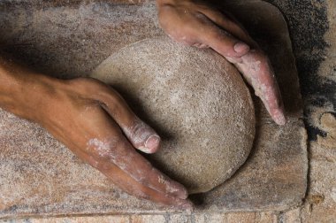 Fırıncı ekmek pişiriyor. Adam hamura un döker. Ekmek yapan adam