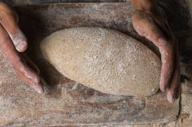 Fırıncı ekmek pişiriyor. Adam hamura un döker. Ekmek yapan adam