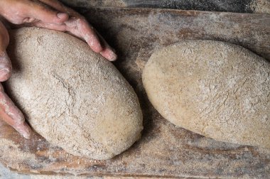 Fırıncı ekmek pişiriyor. Adam hamura un döker. Ekmek yapan adam