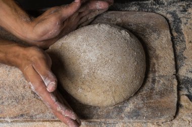 Fırıncı ekmek pişiriyor. Adam hamura un döker. Ekmek yapan adam