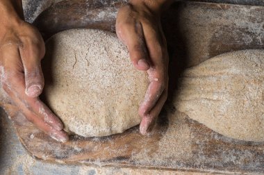 Fırıncı ekmek pişiriyor. Adam hamura un döker. Ekmek yapan adam