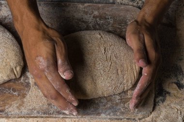 Fırıncı ekmek pişiriyor. Adam hamura un döker. Ekmek yapan adam