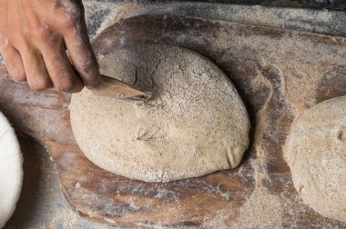 Fırıncı ekmek pişiriyor. Adam hamura un döker. Ekmek yapan adam