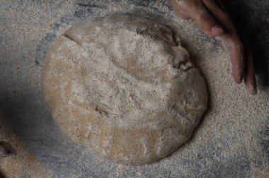 Fırıncı ekmek pişiriyor. Adam hamura un döker. Ekmek yapan adam