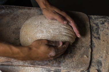 Fırıncı ekmek pişiriyor. Adam hamura un döker. Ekmek yapan adam