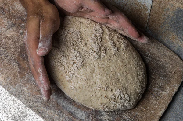 Fırıncı ekmek pişiriyor. Adam hamura un döker. Ekmek yapan adam