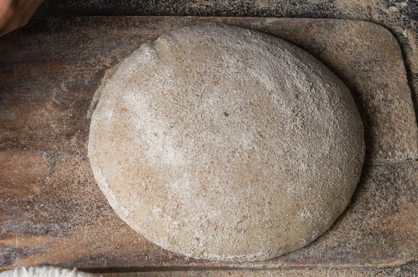 Fırıncı ekmek pişiriyor. Adam hamura un döker. Ekmek yapan adam