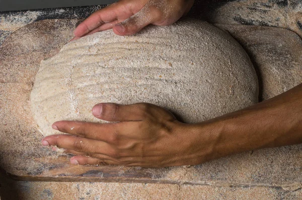Baker cooking bread. Man slaps flour over the dough. Man Making bread