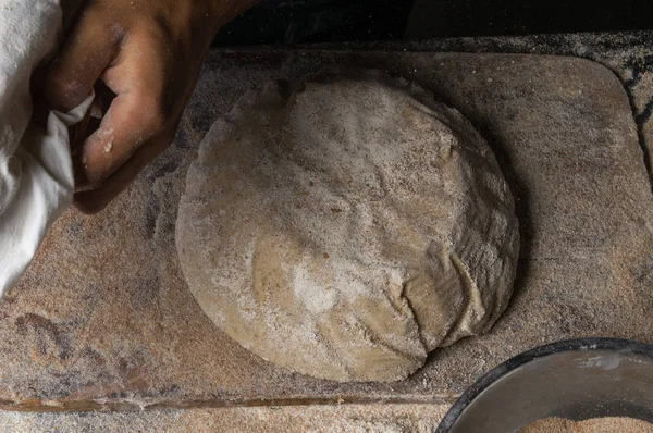 Fırıncı ekmek pişiriyor. Adam hamura un döker. Ekmek yapan adam