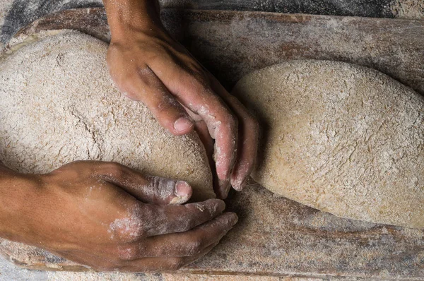 Fırıncı ekmek pişiriyor. Adam hamura un döker. Ekmek yapan adam