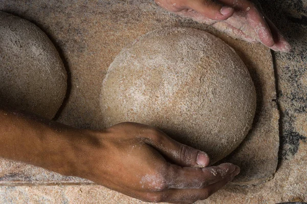 Fırıncı ekmek pişiriyor. Adam hamura un döker. Ekmek yapan adam