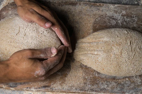 Fırıncı ekmek pişiriyor. Adam hamura un döker. Ekmek yapan adam