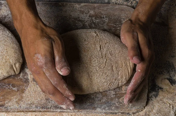 Fırıncı ekmek pişiriyor. Adam hamura un döker. Ekmek yapan adam