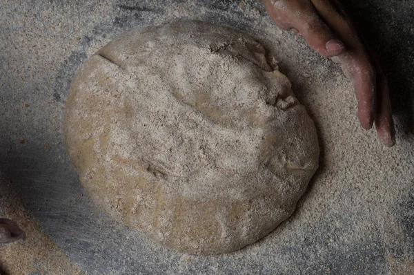 Fırıncı ekmek pişiriyor. Adam hamura un döker. Ekmek yapan adam