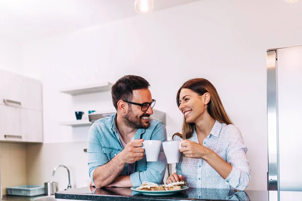 Cute couple cheering with cup of coffee or tea.