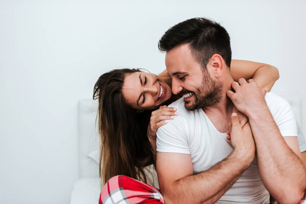 пара обнимается в постели.