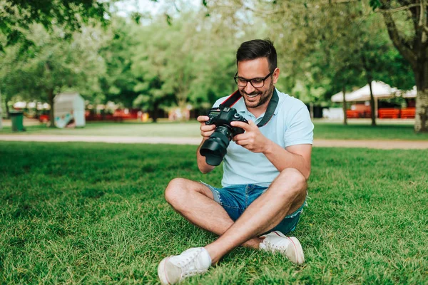 Handsome Young Man Sitting Grass Holding Camera — Stock Photo, Image