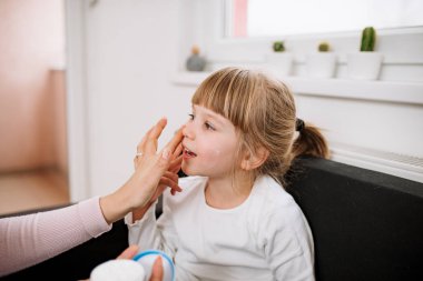 Anne uygulanan yüz Creme kızı yüz üzerinde.