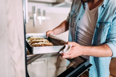 Sıcak Sandviçler fırından alarak genç adam.