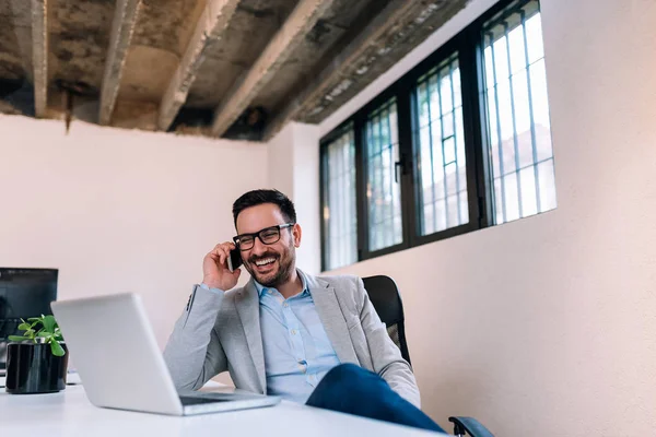 Ofiste otururken cep telefonunuzda konuşurken işadamı.
